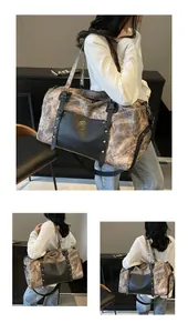 Detalle de bolsa de viaje gris con bolsillo frontal de cuero negro y remaches metálicos