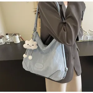 Détail du sac cabas en nylon bleu clair avec un charme de nuage en peluche pour femmes