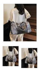 Detalle de bolsa de viaje gris jaspeada con asas de cuero negro y remaches