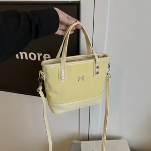 Elegant beige canvas tote bag with leather trim and silver logo for 2025 fashion style