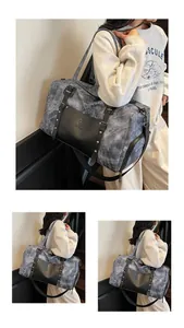 Detalle de bolsa de viaje grande con textura de mármol y acabados con remaches plata