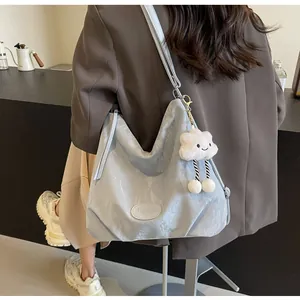 Gros plan détaillé du sac cabas bleu clair texturé avec un pendentif nuage blanc