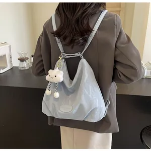 Détail d'un sac cabas en cuir souple bleu clair avec un porte-clés nuage en peluche