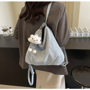 Détail du sac plissé bleu clair avec logo MUDM SHARK et breloque nuage doux