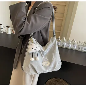 Détail du sac cabas gris clair brillant froissé avec charm nuage et logo métallique