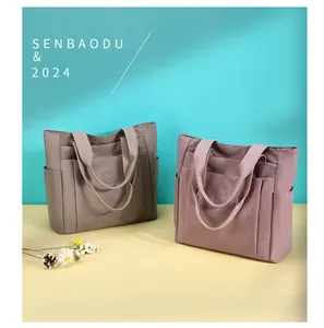 Detail view of large nylon tote bags showing multi-pocket design and durable fabric