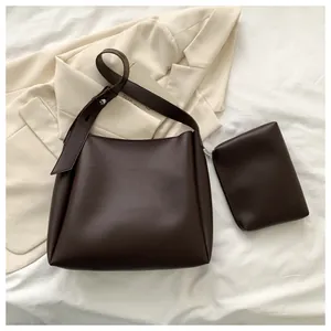 Dettaglio del set borsa tote in ecopelle marrone scuro con tracolla e pochette