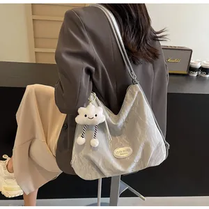 Gros plan d'un sac cabas argenté texturé avec pendentif nuage et détails métalliques