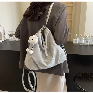 Gros plan sur un grand sac cabas gris clair avec texture métallisée et charme nuage
