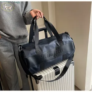 Dettaglio borsa da viaggio blu sul manico della valigia con tracolla regolabile