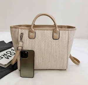 Detailed view of beige woven bucket bag with phone for size comparison