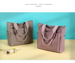 Detail of khaki and pink nylon tote bags showing multiple functional exterior pockets
