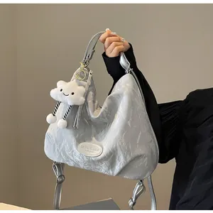 Détail du sac cabas argenté métallisé avec breloque nuage et écusson de la marque