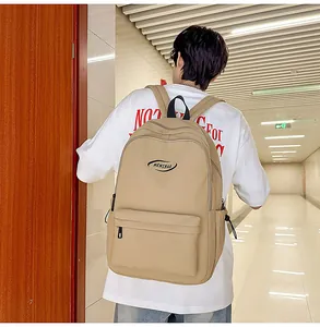 Detail view of khaki waterproof backpack featuring MRMIBAG logo and front pocket