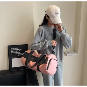 Borsa da palestra cilindrica rosa con tracolla regolabile in un ambiente interno moderno