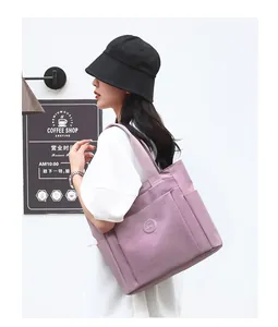 Detail of purple nylon tote bag with large front pocket and side water bottle holder
