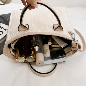 Spacious interior of a beige woven tote bag showing room for tablet and makeup