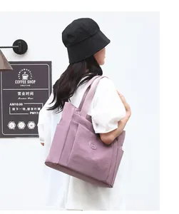 Detailed view of a purple waterproof nylon tote bag with side pockets for daily casual use