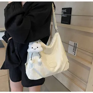 Gros plan d'un sac cabas plissé blanc crème avec charme nuage et bandoulière large