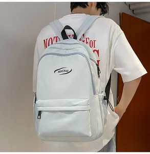 Rear view of a light blue minimalist backpack with adjustable straps and front zip pocket