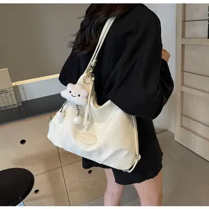 Détail d'un grand sac bandoulière blanc en similicuir avec pendentif nuage pelucheux