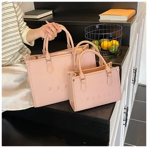 Detail view of pink Paris embroidered tote bags in large and small sizes with twill texture