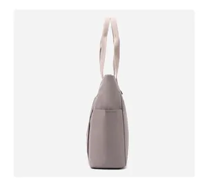 Detailed side view of the taupe nylon shoulder bag featuring a spacious side pocket
