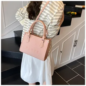 Pink tote bag with Paris embossing shown on a shoulder in a stylish interior