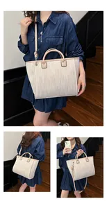 Detalle del bolso tote tejido beige con asas de cuero marrón y correa ajustable