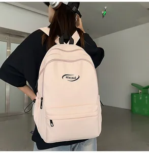 Lifestyle view of a large light pink nylon backpack worn by a model in a casual setting