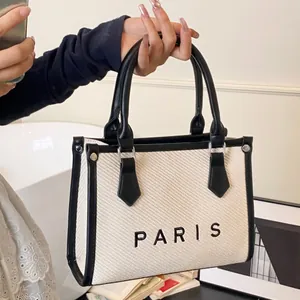 Chic beige canvas tote bag with black PARIS lettering and faux leather top handles
