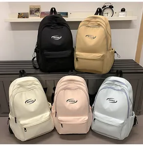 Five assorted colors of large capacity nylon school backpacks arranged in a room