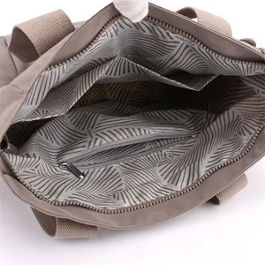 Spacious interior of khaki nylon shoulder bag with striped lining and functional pockets