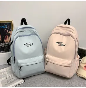 Detail view of light blue and pink school backpacks with multiple zipper compartments