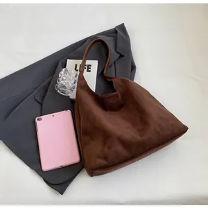 Top-down view of a dark brown suede tote bag with textured finish and leather handle