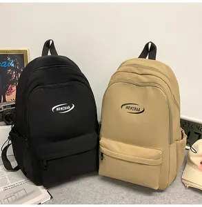 Close-up of waterproof nylon backpacks in black and khaki with front logo detail