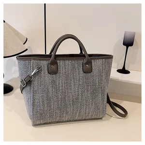 Detalle de textura de tweed y costuras de cuero marrón en bolso tote de gran capacidad