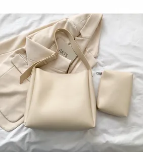 Borsa tote minimalista in ecopelle bianca e pochette abbinata su sfondo lifestyle
