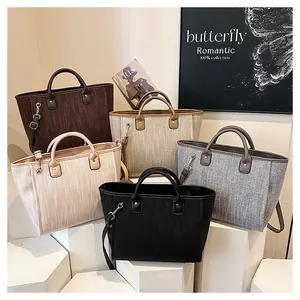 Detalle de bolsos tote tejidos en cinco colores neutros con asas redondas y correas