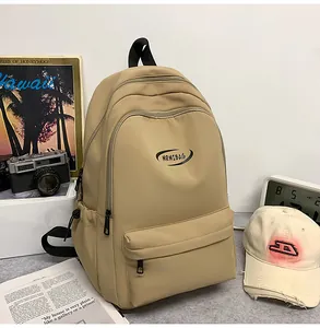 Detail of khaki nylon backpack with MRMIBAG logo beside a vintage camera and book