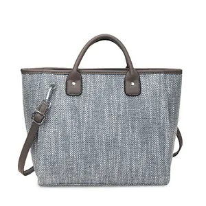 Detalle de la textura de tweed tejido y acabados de cuero marrón en el bolso azul