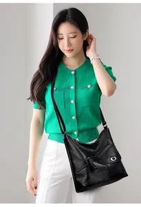 Detailed view of black lychee grain faux leather shoulder bag with multiple functional pockets