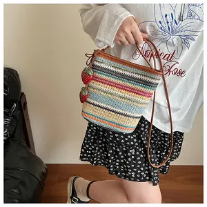 Sac seau tissé coloré porté avec breloques fraises et fines bandoulières en cuir marron