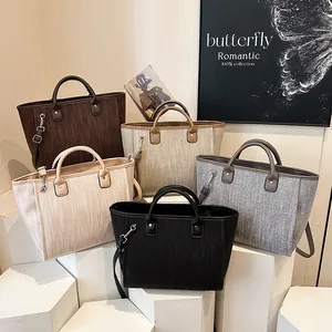 Bolsos tipo cubo trenzados con asas de cuero y correas ajustables en tonos neutros