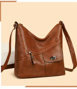 Macro detail of retro brown crossbody bag showing zipper pocket and metallic turn-lock closure