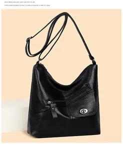 Close-up of black leather crossbody bag featuring silver hardware and a metal twist lock