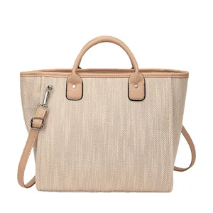 Bolso saco de tejido beige con asas de cuero marrón y correa ajustable para el hombro
