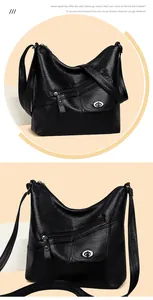 Detail of black faux leather shoulder bag with multiple zipper pockets and adjustable strap