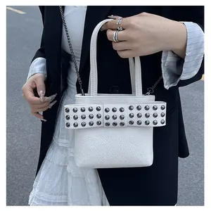 Gros plan du sac à main blanc en cuir grainé avec grand nœud et détails cloutés