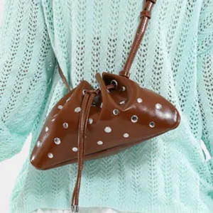 Brown drawstring bucket bag with silver rivets and minimalist crossbody strap design